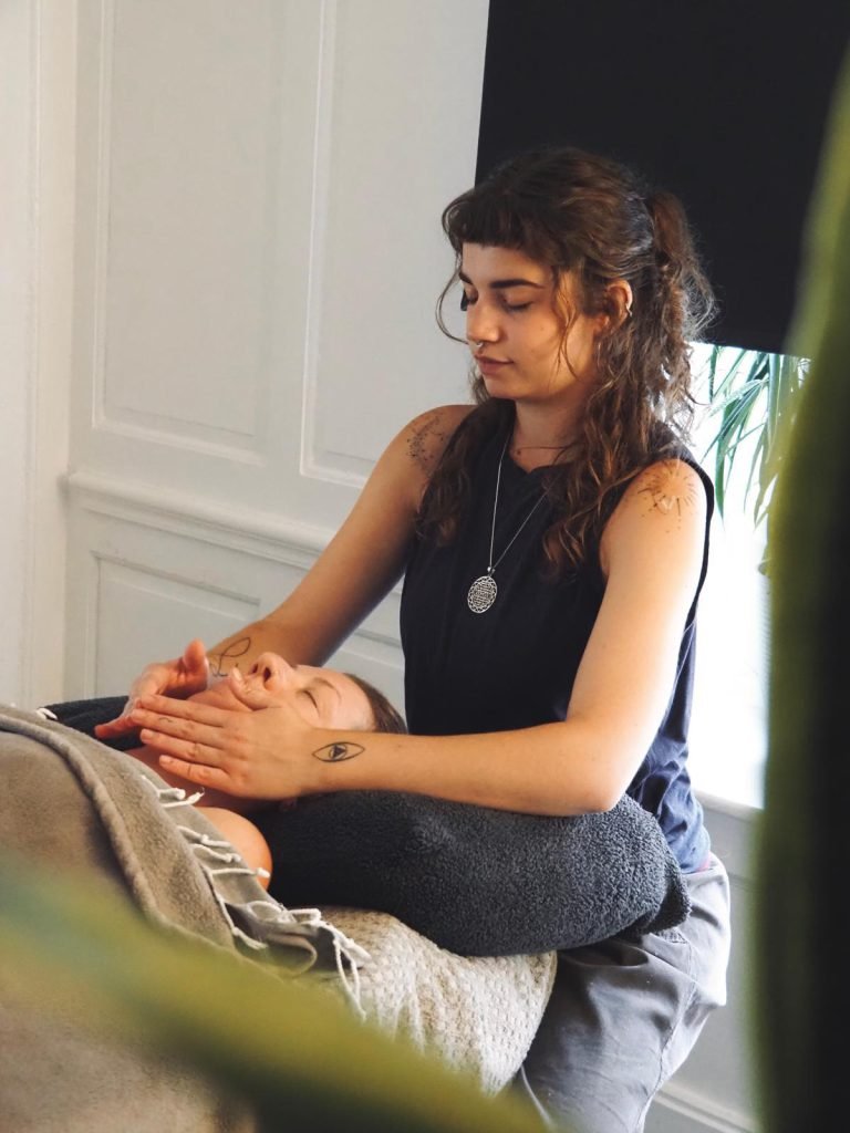 Emma Foster with her hands resting lightly at a client’s head during Reiki