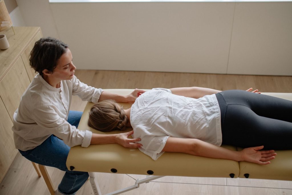 A practitioner working on someone lying on a treatment couch