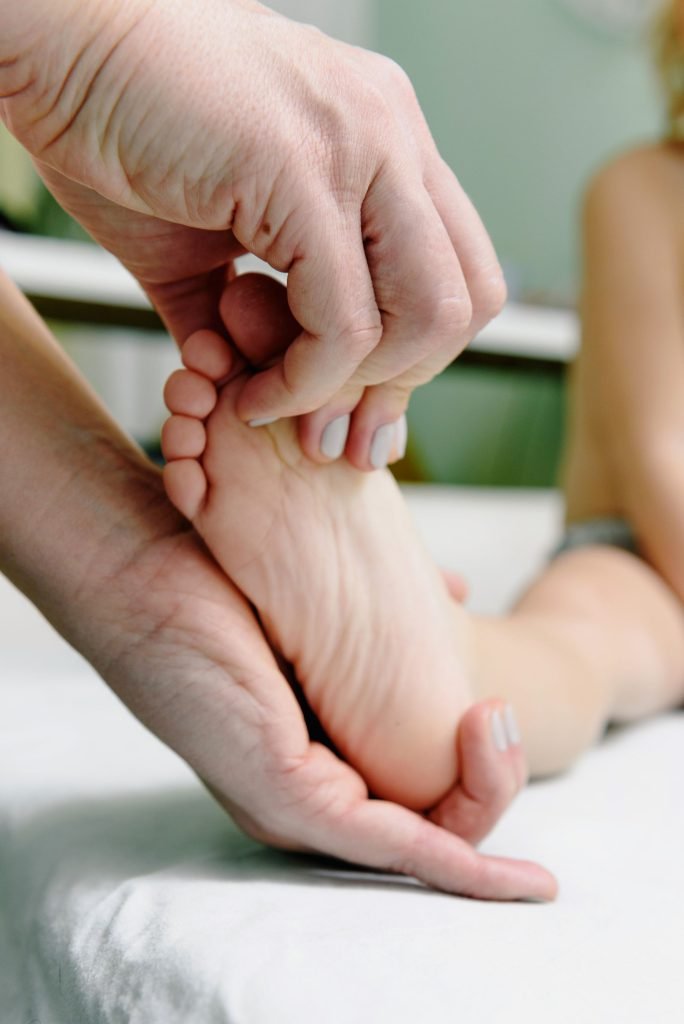 A reflexologist working with gentle pressure on a foot
